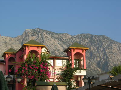Вид утром обалденный!розовое здание, в цветах, на фоне гор!