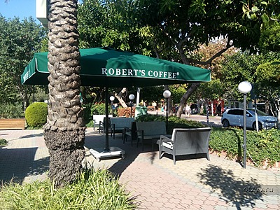 Часть кафе Robert's Coffee возле детской площадки в парке на набережной